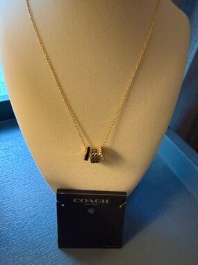 COACH Gold and Black Three Ring Barrel Pendant Necklace with Signature Cutouts